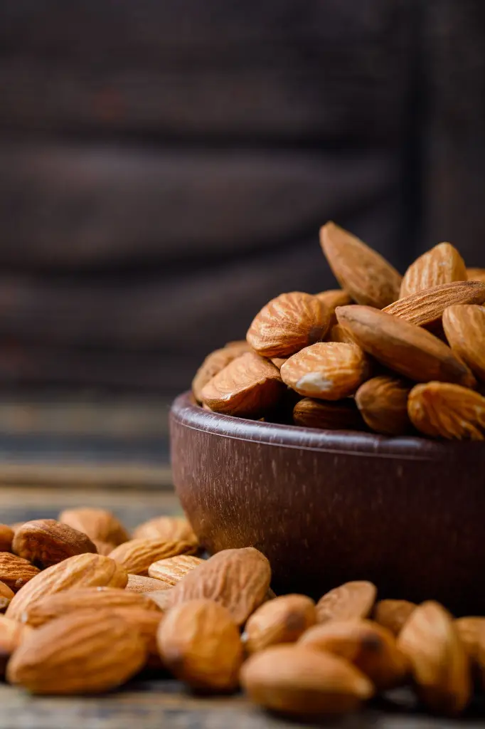 peeled-almonds-clay-plate-stone-tile-wooden-background (1).webp